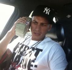 a man sitting in the back seat of a car holding money