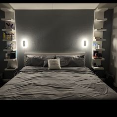 there is a bed with two lights on the headboard and shelves in the wall behind it