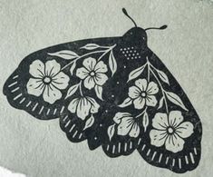 a black and white butterfly with flowers on it's wings