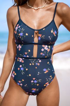 The Cheerful Navy Floral Scoop Cutout One-Piece is a delightful choice for soaking up the sun with style. Its navy blue base adorned with vibrant floral prints exudes a cheerful and playful vibe, perfect for beach days or poolside lounging. The scoop neckline adds a touch of classic charm, while the cutout detailing adds a modern and flirty twist to the design. Product code: CAA12E4D046UW Features:  Scoop neckline Adjustable straps Removable soft cups Back tie Cutout Moderate leg cut Moderate bu Blue Printed Summer Swimwear, Blue Printed Swimwear For Summer, Blue Floral Print Swimwear, Blue Printed Tankini For Spring, Spring Blue Printed Tankini, Blue Printed Spring Tankini, Blue Floral Print Tankini For Sunbathing, Blue Floral Print Swimwear For Beach Party, Blue Floral Print Tankini For Pool