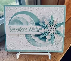 a snowflake wish for a merry christmas card on a table next to a window