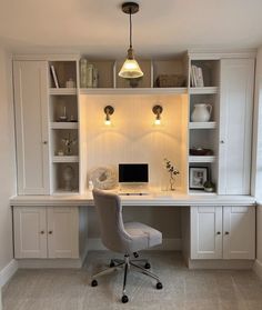 a home office with built - in shelving, desk and chair