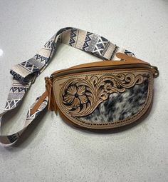 This bag is handtooled and designed and ready for a day at the rodeo, fair, vacation, or even your small daily  shopping trip. For an extra $75 I can make a matching tooled strap with your name, brand, initials or just matching florals!  PLEASE NOTE: If you choose a custom made strap the shipping time will take an extra two weeks!! Leather Bags With Concho For Everyday Use, Western Style Hand Tooled Shoulder Bag For Travel, Southwestern Hand Tooled Bags For Everyday Use, Hand Tooled Leather Bags For Rodeo, Hand Tooled Crossbody Travel Bag, Hand Tooled Leather Shoulder Bag With Double Handle, Hand Tooled Brown Bags For Rodeo, Western Hand Tooled Bags For Daily Use, Hand Tooled Brown Bag For Rodeo