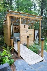 a small wooden structure in the middle of a forest with stairs leading up to it