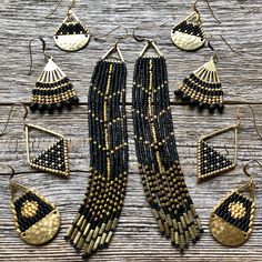 black and gold beaded jewelry set sitting on top of a wooden table next to earrings