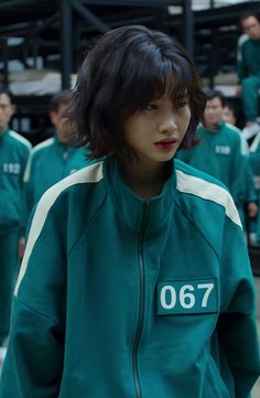 a group of young people standing next to each other in front of a crowd wearing green and white tracksuits