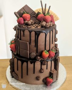 a chocolate cake with strawberries and chocolate decorations