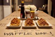 a table topped with three plates of waffles