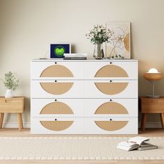 a white dresser with brown circles on it in a living room next to a lamp