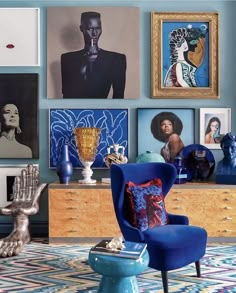 a blue chair sitting in front of a wall with pictures on it's walls