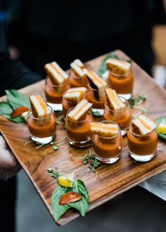 there are many small desserts on the wooden platter that is ready to be served