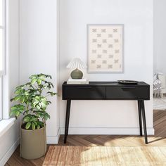 a black desk with a lamp and potted plant on it next to a window