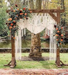 an outdoor wedding ceremony setup with macrami and roses on the arbor, surrounded by greenery