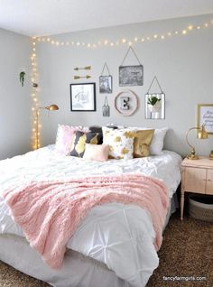 a white bed with pink and gold pillows in a bedroom decorated for christmas or new year's eve