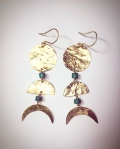 two gold earrings with green beads hanging from them