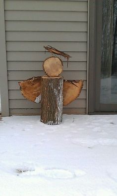 a fire hydrant made out of logs in the snow