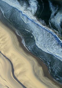 an aerial view of the ocean and sand