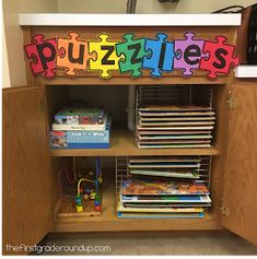 a bookcase with puzzles on it and books in the bins under the shelf