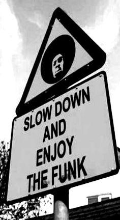 a black and white photo of a sign that says slow down and enjoy the funky