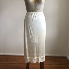 - Vintage 90's slip skirt  - a lovely off white/light beige shade  - lace trim round hem  - elastic waist  - the fabric is polyester slightly sheer  - fits best an AUS 10 US 6 UK 10 EU 38                                       - MEASUREMENTS -  WAIST - 22 in to 32 in   HIPS - 40 in  LENGTH - 30 in  I wash and clean all my dresses so they will always arrive fresh and ready to wear  I combine postage -  $2 extra each item within Australia  $8 extra each item international  *If package is lost once Vintage Bottoms With Lace Trim For Summer, Vintage Lace Trim Bottoms For Summer, Vintage Long Skirt With Lace Trim, Feminine Cream Skirt With Lace Trim, Summer Fitted Skirt With Delicate Lace, Fitted Summer Skirt With Delicate Lace, Feminine Cream Skirt For Daywear, Spring Skirt With Lace Trim And Stretch, Beige Flowy Lace Skirt