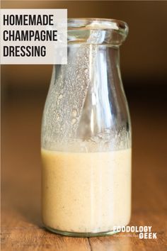 homemade champagne dressing in a glass bottle on a wooden table with text overlay that reads homemade champagne dressing