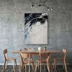 a dining room table with four chairs and a painting on the wall above it,