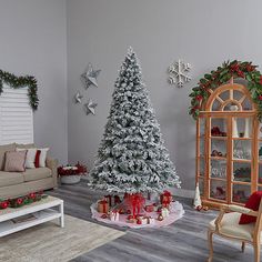 a living room decorated for christmas with white and red decorations