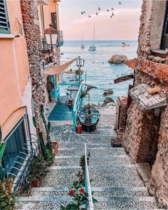 an alley leading to the beach with boats in the water