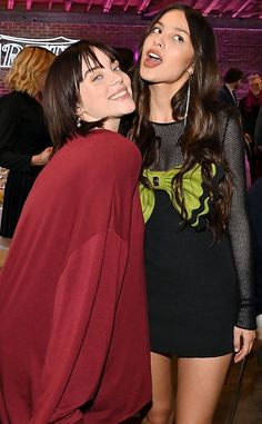 two women standing next to each other at a party