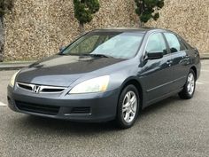 a gray honda accord is parked in a parking lot