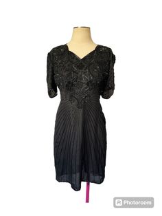 This vintage Scala dress is a stunning little black dress from the 80s or 90s. The beaded design adds a touch of glamour to any occasion, making it perfect for a night out or a special event. The dress is made with high-quality materials and has been well-maintained over the years, ensuring its timeless beauty. The brand name is prominently displayed, adding to its appeal and authenticity. Whether you're a fan of vintage fashion or simply looking for a unique dress, this Scala little black dress is sure to impress. Black Vintage Dress For Formal Summer Events, Black Vintage Summer Dress For Formal Occasions, Black Vintage Dress For Summer Formal, Fitted V-neck Vintage Party Dress, Elegant Beaded Mini Dress For Party Season, Elegant Fitted Vintage Party Dress, Elegant Fitted Vintage Dress For Party, Chic Vintage Short Sleeve Party Dress, Chic Short Sleeve Vintage Party Dress