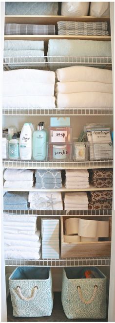 an organized closet with white shelving and baskets filled with towels, toiletries and other items