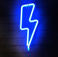 a blue neon sign hanging from the side of a brick wall