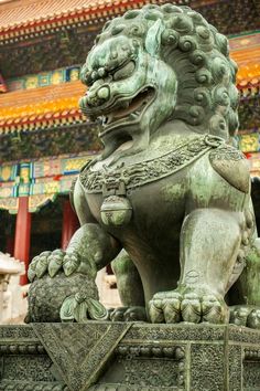 a stone lion statue in front of a building