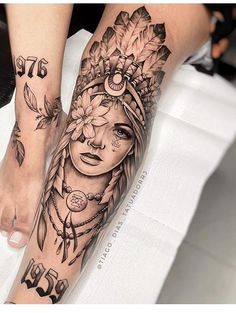 a woman's leg with tattoos on it and flowers in her hair is shown