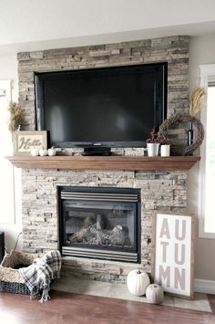 a living room with a fireplace and television on top of the mantel above it