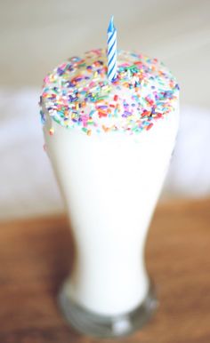 a birthday cake with sprinkles and a single candle sticking out of it