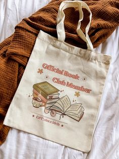 a book bag sitting on top of a bed next to an orange blanket and pillow