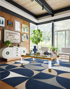 a living room filled with furniture and a blue rug on top of a wooden floor