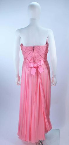 For Sale on 1stDibs - This Scaasi gown is composed of a pink chiffon. The bodice has a criss-cross design. The skirt features a drape style. There is a center back zipper closure Pre-draped Pink Silk Evening Dress, Silk Evening Gown With Boned Bodice, Silk Gown With Boned Bodice For Evening, Formal Pre-draped Pink Gown, Pink Sleeveless Evening Dress With Pleated Bodice, Fitted Gown With Sheer Bodice In Georgette, Chiffon Gown With Pleated Bodice For Gala, Fitted Georgette Gown With Sheer Bodice, Pink Gown With Pleated Bodice And Sweetheart Neckline