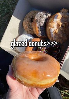 someone is holding up a donut that has glazed doughnuts > > >