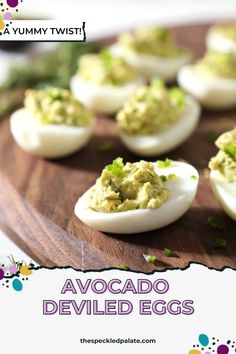 deviled eggs with guacamole and chives on a wooden platter