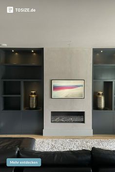 a modern living room with black leather couches and built - in bookcases