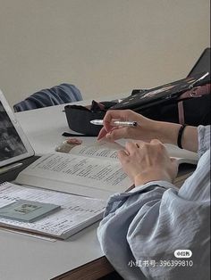 a person sitting at a desk with an open book