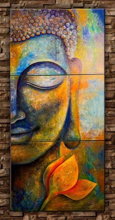 a painting on a brick wall with a buddha face and flower in the foreground