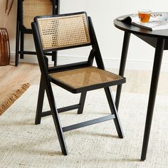 two chairs sitting next to each other on top of a rug in front of a table