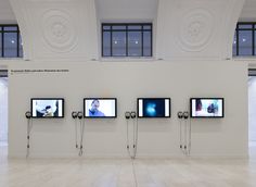 four televisions mounted to the wall in an empty room