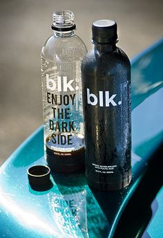 two empty water bottles sitting on top of a blue surfboard