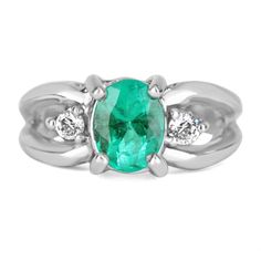 Displayed is a Colombian emerald and diamond ladies ring. Perfectly handcrafted in solid 14K white gold, this opulent ring features a bright, green Colombian emerald oval that is set in a secure four prong setting. On either side of the center stone are large brilliant round diamonds are also prong set. A beautiful split shank adds width to the ring. A perfect gift for someone you love or even for yourself! Metal Purity: 14K White Gold Weight: 6.8 grams Setting Style: Prong Main Stone: Colombian Oval Emerald Ring With Prong Setting In Platinum, Oval Platinum Emerald Ring With Prong Setting, Classic Oval Diamond Ring For May Birthstone, Oval Emerald Ring With Diamond Accents For Formal, Oval Solitaire Diamond Ring For May Birthstone, Oval Emerald Ring In White Gold With Diamond, Formal Oval Cluster Ring With Solitaire, Anniversary Oval Link Ring With Polished Finish, Oval Emerald Ring With Diamond Center Stone