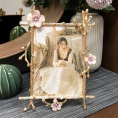 a photo frame sitting on top of a table next to flowers